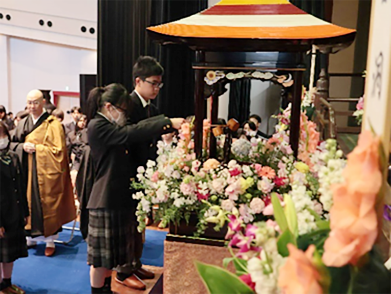代表生徒が甘茶をかける花祭りの写真